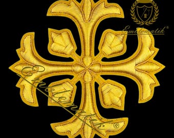May include: A gold embroidered cross with a floral design. The cross is on a black background.