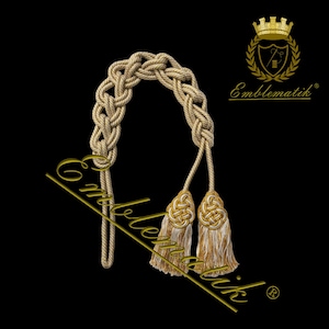 Puede incluir: Dos ataduras de cortina de cuerda trenzada dorada y blanca con un diseño de nudo. Las ataduras están hechas de una cuerda gruesa trenzada con un borla en cada extremo. Las borlas están hechas de un material suave y esponjoso y son de color dorado claro. Las ataduras son perfectas para agregar un toque de elegancia a cualquier habitación.