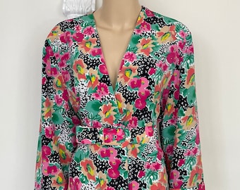 May include: A long-sleeved dress with a V-neckline and a floral print. The dress has a belt and is made of a lightweight fabric.