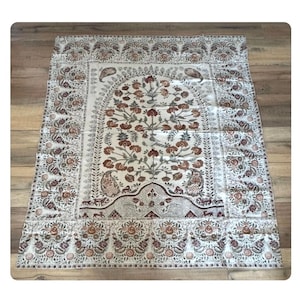 May include: Cream-colored textile with an intricate floral design in shades of brown, red, and green. The central motif features a stylized tree, framed by an arched border. The edges are adorned with repeating floral patterns.