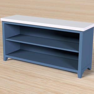 Pode incluir: Um arm&aacute;rio de armazenamento azul com duas prateleiras e um tampo branco. O arm&aacute;rio &eacute; feito de madeira e tem um design simples e moderno. As prateleiras s&atilde;o perfeitas para guardar livros, decora&ccedil;&atilde;o ou outros itens.