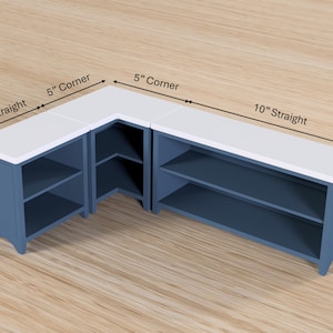 Pode incluir: Um arm&aacute;rio de canto azul com uma bancada branca. O arm&aacute;rio tem prateleiras abertas e mede 12,7 cm reto, 12,7 cm canto e 25,4 cm reto. O arm&aacute;rio &eacute; feito de madeira e tem um design moderno.