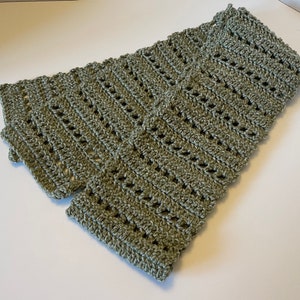 May include: A green crocheted scarf with a lacy pattern.