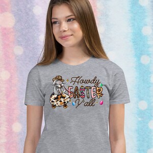 May include: Gray t-shirt with a cartoon bunny wearing a cowboy hat and riding an Easter egg. The text "Howdy Easter Y'all" is printed on the shirt.
