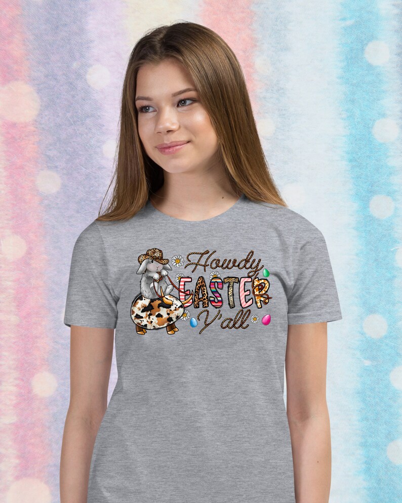 May include: Gray t-shirt with a cartoon bunny wearing a cowboy hat and riding an Easter egg. The text "Howdy Easter Y'all" is printed on the shirt.