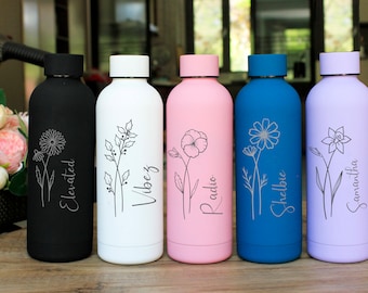 May include: Five stainless steel water bottles with different colored exteriors and floral designs. The bottles are engraved with the names "Elevated", "Vibez", "Radio", "Shelbie", and "Samantha".