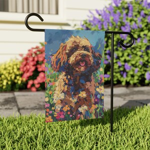 Puede incluir: Una bandera de jardín colorida con un perro marrón y blanco con una expresión feliz, rodeado de una variedad de flores coloridas. El perro está de pie en un campo de hierba con un cielo azul de fondo.