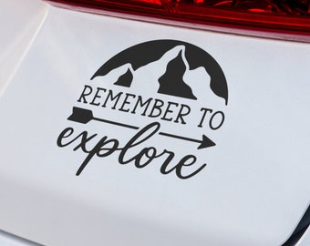 May include: Black and white car sticker with a mountain silhouette and an arrow pointing to the right. The text "Remember to explore" is written below the mountain.