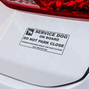 May include: A rectangular white sticker with black text and a graphic of a dog. The text reads "SERVICE DOG ON BOARD, DO NOT PARK CLOSE, HANDLER REQUIRES SPACE FOR SAFE ACCESS, ADA PROTECTED."