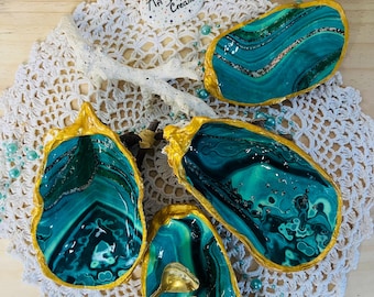 Zout- en peperstrooier set met decoratieve oesters en kleine gouden lepeltjes.