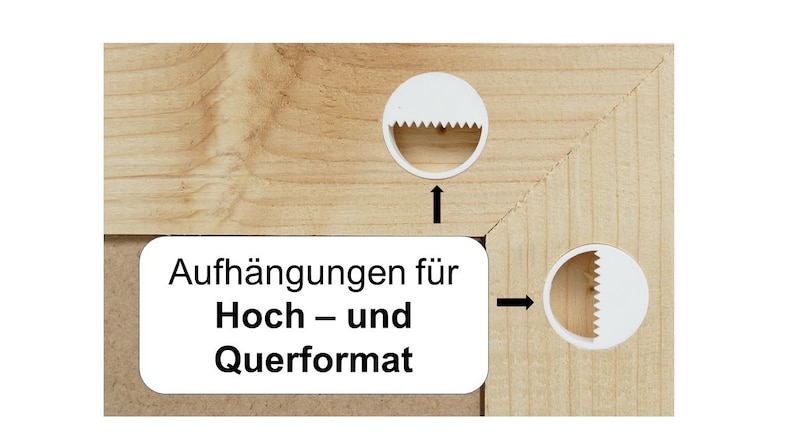 May include: A light-colored wooden frame corner featuring two white circular sawtooth hangers attached to the wood. A white rectangular label with black text reads: Aufh&auml;ngungen f&uuml;r Hoch &ndash; und Querformat. Two black arrows point to the hangers.