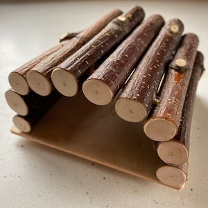 May include: A small wooden tunnel made of multiple brown sticks, perfect for small animals to play in. The tunnel is on a wooden base.
