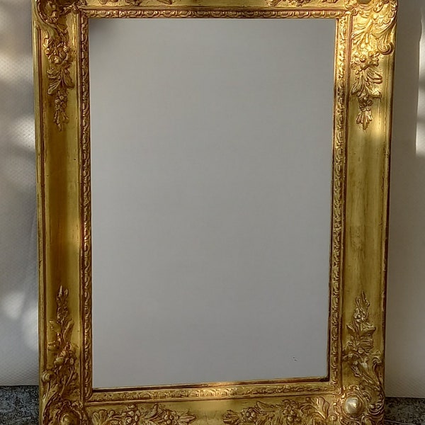 Miroir en bois doré XIXème de style romantique avec coins ornés. XIXth century gilded mirror with floral ornements.