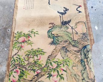 May include: An antique Chinese painting on aged paper. Two red-crowned cranes stand on a rock formation, with a peach tree in the foreground. The painting features detailed brushstrokes and calligraphy.