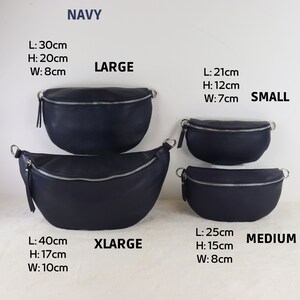 May include: Four navy blue leather fanny packs in different sizes: small, medium, large, and extra large. The sizes are labeled with measurements in centimeters.  NAVY is written at the top of the image.