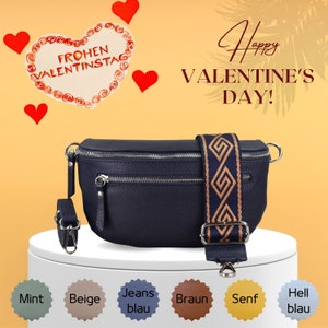 Op de afbeelding: Een donkerblauwe leren heuptas met een bruin en gouden gepatenteerde band. De band heeft een geometrisch ontwerp. De tas heeft een ritsvak aan de voorkant. De tekst "Happy Valentine's Day!" staat op de achtergrond.