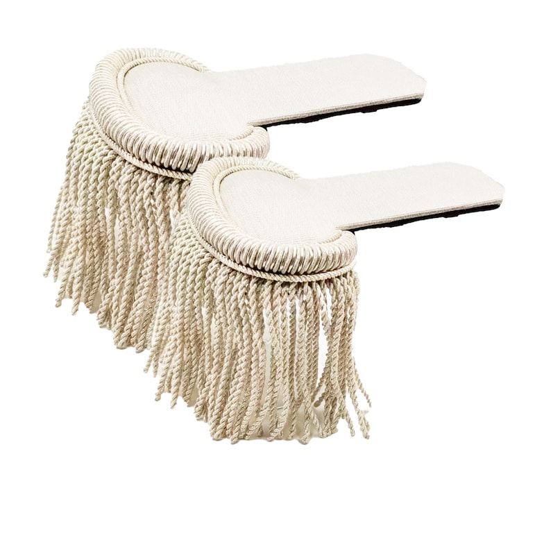 May include: Two white military-style shoulder boards with a fringe trim. The boards are made of a stiff fabric and have a curved shape.