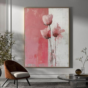 May include: Abstract painting featuring pink flowers on a pink and white background. The painting is framed in a gold frame.