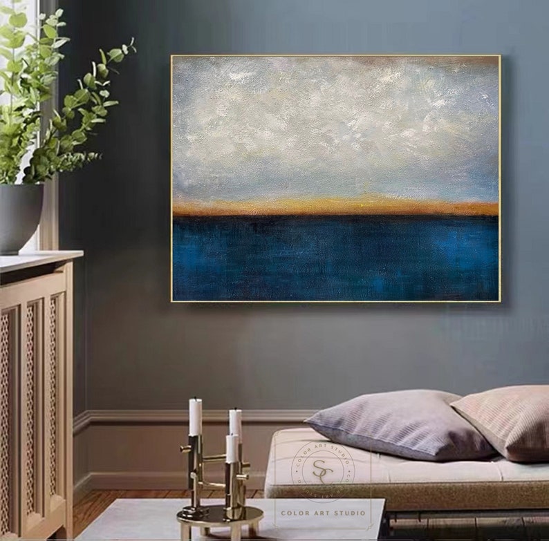 Puede incluir: Pintura abstracta con una combinaci&oacute;n de colores azul y blanco. La pintura representa un paisaje mar&iacute;timo con una l&iacute;nea de horizonte y un cielo nublado. La pintura est&aacute; enmarcada en un marco dorado.