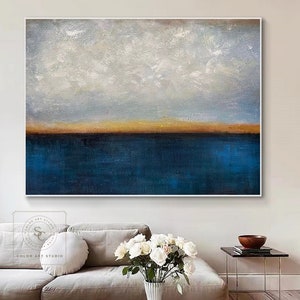 Puede incluir: Pintura abstracta de un paisaje mar&iacute;timo con un oc&eacute;ano azul y un cielo blanco nublado. El horizonte es una fina l&iacute;nea dorada.