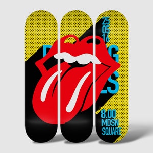May include: Three yellow and black skateboard decks with a red tongue and lips graphic and the text "Rolling Stones" in blue. The right deck also has the text "25 05 16" and "8.00 MDSN SQUARE" in blue.