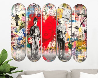 May include: Set of four skateboard decks with colorful, abstract designs featuring iconic figures like Mickey Mouse, Charlie Chaplin, Marilyn Monroe, and Albert Einstein. The decks are decorated with graffiti-style artwork and text, including the phrase "Love is the answer".