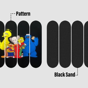 Peut inclure: Quatre planches de skateboard noires avec un motif de personnages de Sesame Street sur le devant. Le motif repr&eacute;sente Big Bird, Elmo, Cookie Monster et un personnage de la marque 'KAWS'. Les planches sont &eacute;tiquet&eacute;es 'Pattern' et 'Black Sand'.