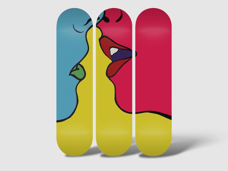 May include: Three skateboard decks with a colorful abstract design of two faces kissing. The faces are yellow, blue, and pink.