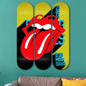 May include: Three yellow and black skateboard decks with a red tongue and lips graphic. The middle deck has the text "25 05 16" and the right deck has the text "8.00 MDSN SQUARE".