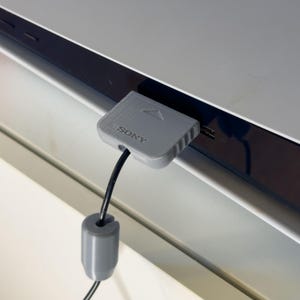 May include: A grey Sony PlayStation 2 memory card with a black cable attached. The memory card is plugged into the console.