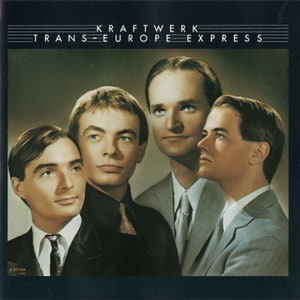 May include: Album cover for Kraftwerk's "Trans-Europe Express." The image features four men in suits, with the album title and band name at the top. The men are in a close-up shot, with a dark background.