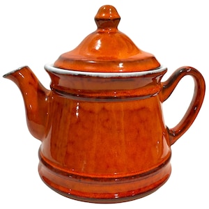 May include: A ceramic teapot with a glossy, orange-brown glaze. The teapot has a lid with a small knob, a curved handle, and a spout. The rim of the lid and the spout are trimmed with white. A classic kitchenware item.
