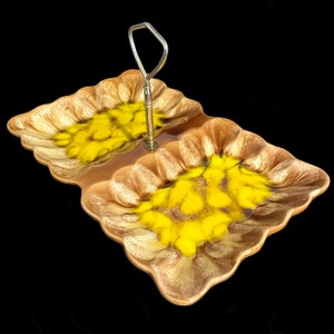 May include: A two-tiered serving tray with a metal handle. The tray is made of ceramic and has a brown and yellow glaze. The glaze has a swirled pattern.
