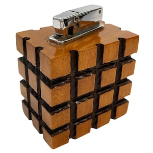 May include: A wooden stapler with a chrome stapler mechanism. The stapler is made of interlocking wooden blocks, stained in a warm brown color. The design is a unique, geometric cube shape.