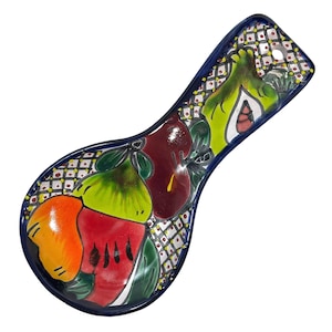 May include: A colorful ceramic spoon rest with a blue border and a design of pears and apples. The pears are green, yellow, and orange, and the apples are red and purple.