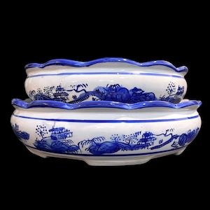 Peut inclure: Deux pots de fleurs en céramique bleu et blanc avec un bord festonné et un motif de paysage chinois traditionnel.
