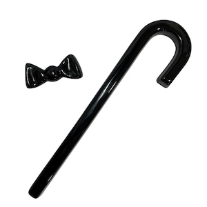May include: A black ceramic bow tie and a black ceramic walking stick.