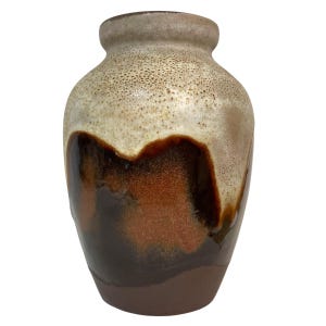 Puede incluir: Un jarrón de cerámica con una parte superior beige moteada, que transiciona a un centro marrón y cobrizo, y una base marrón oscuro. El jarrón tiene un cuerpo redondeado y un cuello estrecho, adecuado para la decoración del hogar.