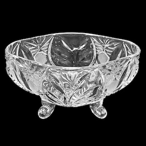 以下が含まれることがあります： 詳細なカットガラスのデザインが施された、透明な楕円形のクリスタルボウル。ボウルは花の模様で、3つの小さな丸い足の上に置かれています。複雑なカットが、きらめく効果を生み出しています。