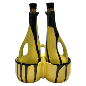 May include: A yellow and black ceramic oil and vinegar set with two bottles and a drip tray. The bottles have a unique drip design and are perfect for serving oil and vinegar.