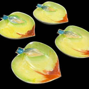 May include: Four leaf-shaped decorative dishes. Each dish has a yellow and green colour scheme with a touch of orange and a silver rim. The dishes have a blue accent and a leaf design.