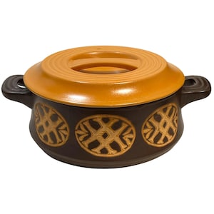 Puede incluir: Una fuente de cerámica marrón con tapa y asa naranja. La fuente tiene dos asas y está decorada con tres diseños ovalados en un marrón más claro. Adecuada para cocinar.