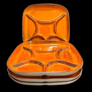 May include: Set of three orange ceramic divided serving plates. Each plate has a central section and four smaller sections around the edge.