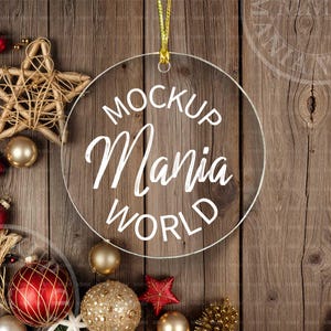 May include: A clear glass ornament with the text "MOCKUP MANIA WORLD" written in white on a wooden background with Christmas decorations.
