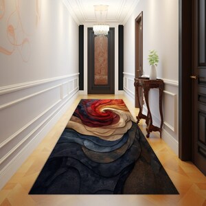 May include: A long, narrow, abstract rug with swirling patterns in shades of red, orange, yellow, blue, and brown. The rug is laid out in a hallway with white walls and wooden floors.