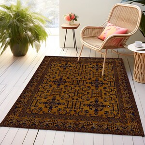 May include: A gold and black patterned rug with a geometric design. The rug has a dark border and a central medallion. The rug is on a light wood floor.