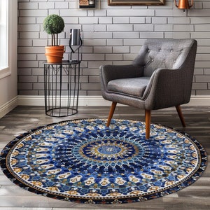 May include: A round blue and gold patterned rug with a mandala design. The rug is on a wooden floor in a room with a grey armchair and a black metal side table.