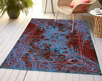 Puede incluir: Una alfombra azul y roja con un diseño floral. La alfombra tiene un borde con un patrón repetitivo. La alfombra está sobre un suelo de madera.