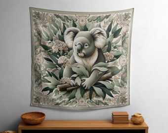 May include: A tapestry depicting a koala bear sitting in a eucalyptus tree. The tapestry has a cream background with green leaves and white flowers. The koala is grey and has a white chest.
