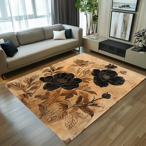 May include: A beige area rug with a floral design featuring large black flowers and brown leaves. The rug has a distressed, vintage look.